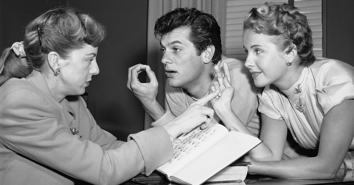 Skådisarna Tony Curtis och Mona Freeman lär sig teckenspråk inför en filminspelning 1951.