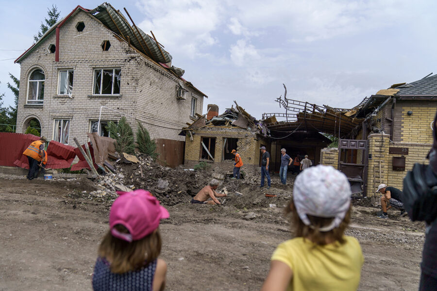 Barn tittar på under röjningsarbetet efter en attack mot ett hus i Kramatorsk.