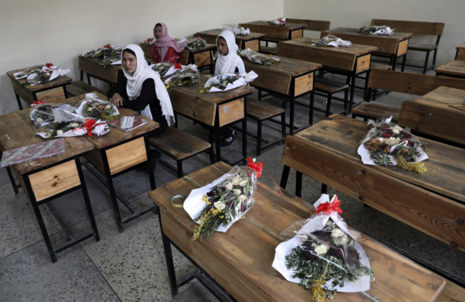 Flickor i en skola i Afghanistans huvudstad Kabul med blommor på de bänkar där klasskamrater som dödats suttit.
