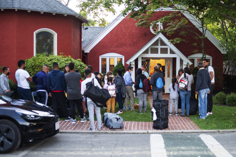 Migranter som flugits från Florida samlas utanför en kyrka på semesterön Martha's Vineyard.