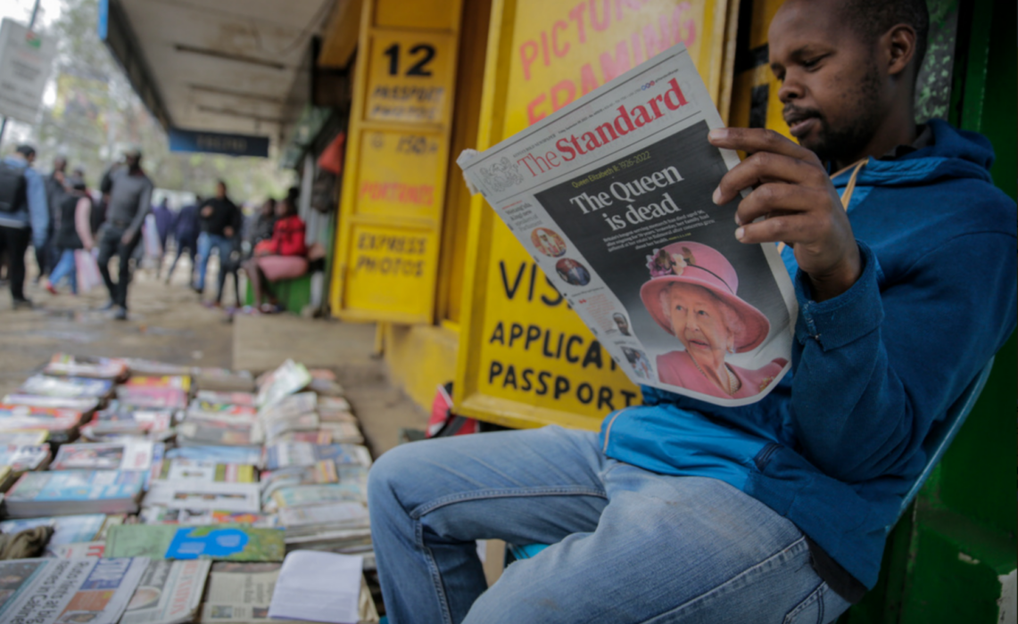 En tidningsförsäljare läser nyheten om drottning Elizabeths död i Kenyas huvudstad Nairobi.