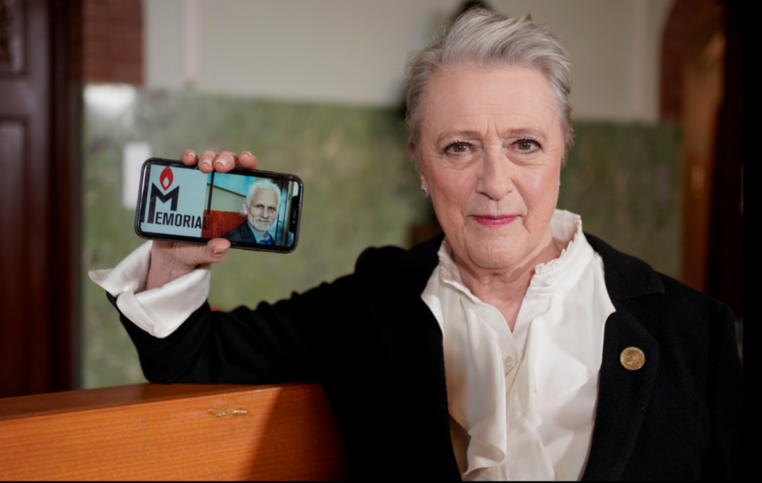 Nobelkommitténs ordförande Berit Reis-Andersen håller upp en bild på Ales Bjaljatski och organisationen Memorials logga, som tillsammans med organisationen Center for Civil Liberties tilldelades årets fredspris.