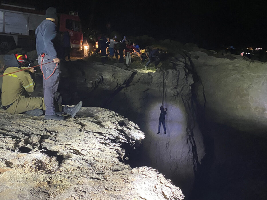 Räddningsarbetare och lokalinvånare arbetar för att rädda en migrant på ön Kythira efter att en segelbåt gått på grund i hårt väder.