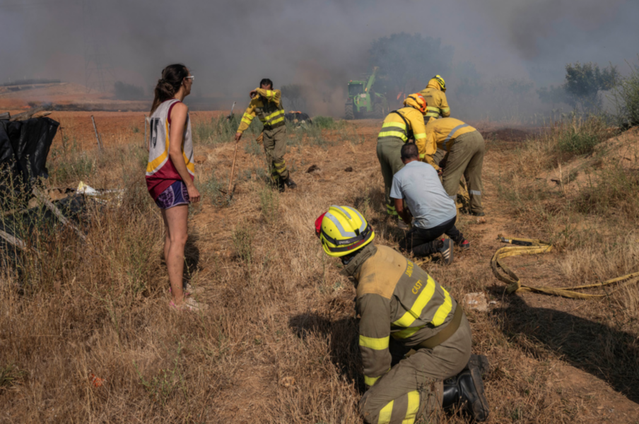 Brandkår i nordvästra Spanien i färd med att släcka en brand som letade sig närmare ett bostadshus.