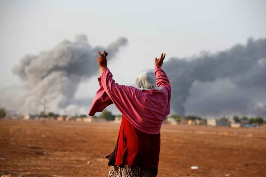 En kurdisk kvinnan firar efter att den USA-ladda koalitionen bombat ett IS-fäste i Kobanî 2014.