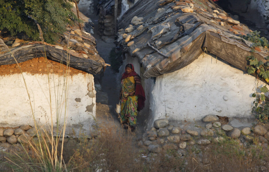 En kvinna i Indien på väg till toaplatsen i det öppna.