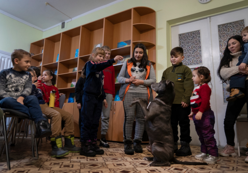 Barn och unga på ett offentligt centrum för psykologiska stödinsatser utanför Kiev får träffa pitbullterriern Bice.