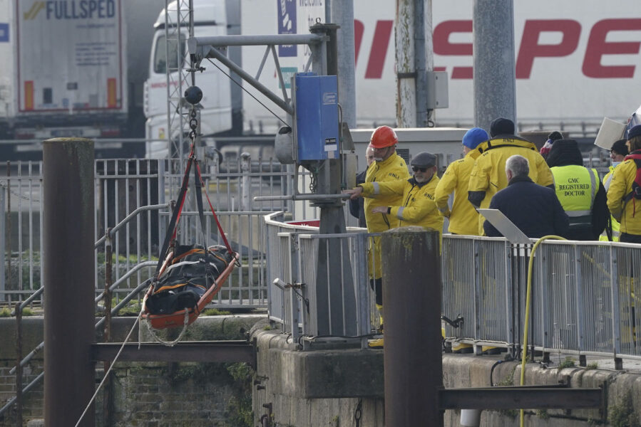 En bår med en liksäck flyttas från en livbåt till fast mark efter ankomst till hamnen i Dover.
