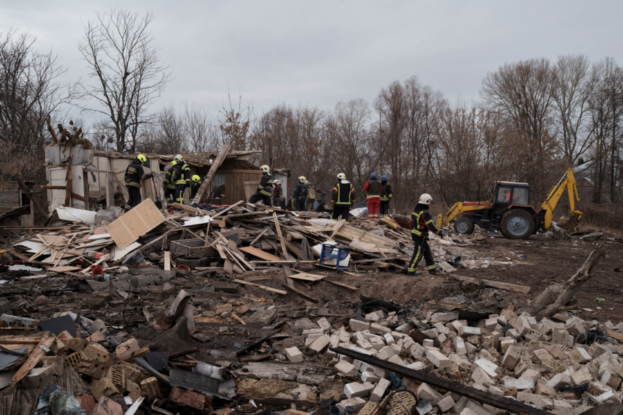 Räddningsarbetare röjer undan bråte sedan ett hus förstörts i en robotattack i Kiev under torsdagen.
