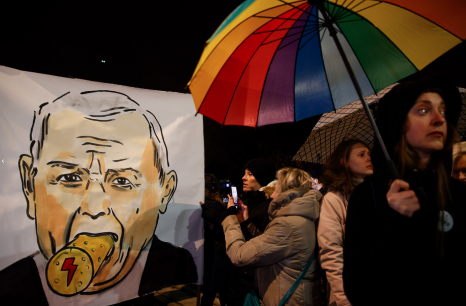 Warszawabor protesterar framför Jaroslaw Kaczynskis hus den 28 november, med en karikatyr på partiledaren där en kork pluggar igen hans mun.
