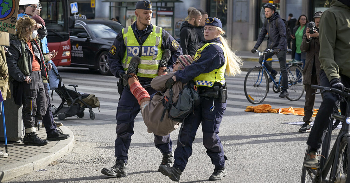 En Extinction rebellion-aktivist bärs bort från Sveavägen i Stockholm.