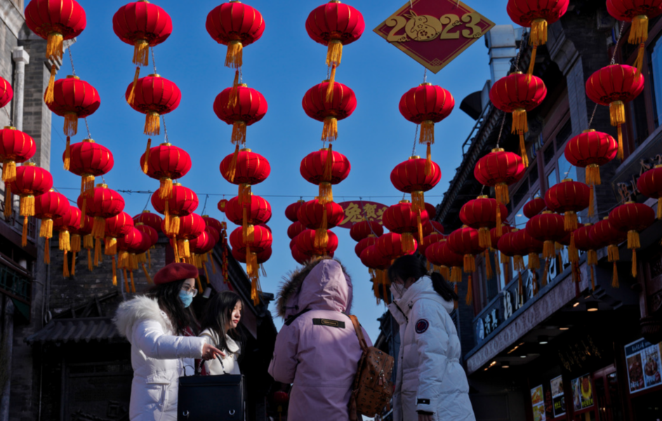 Kvinnor på en shoppinggata i Peking, dekorerad med röda lyktor inför nyårsfirandet.