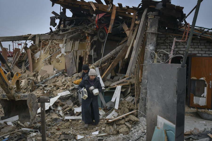 Invånare tar med sig några tillhörigheter när de lämnar ruinerna som en gång var deras hem efter ett raketanfall i Zaporizhzhya, Ukraina.
