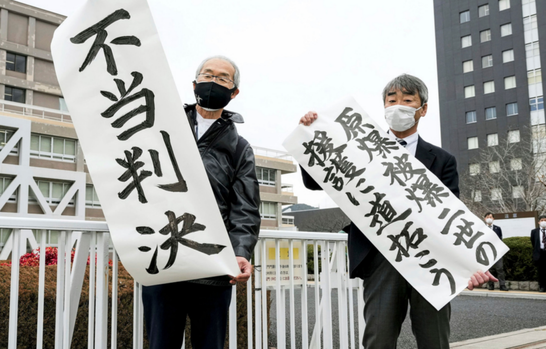 Katsuhiro Hirano och hans advokat protesterar efter domen i Hiroshima.