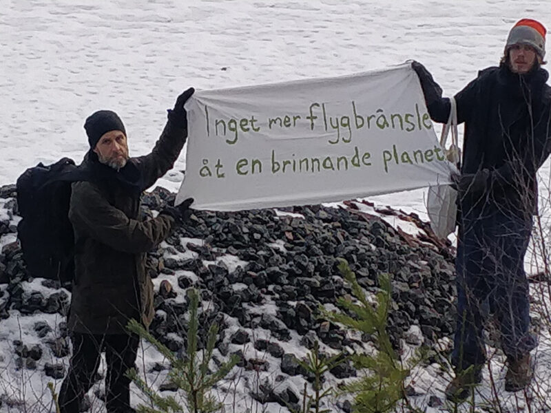 Två aktivister vid spåren som fraktar flygbränsle till Arlanda.