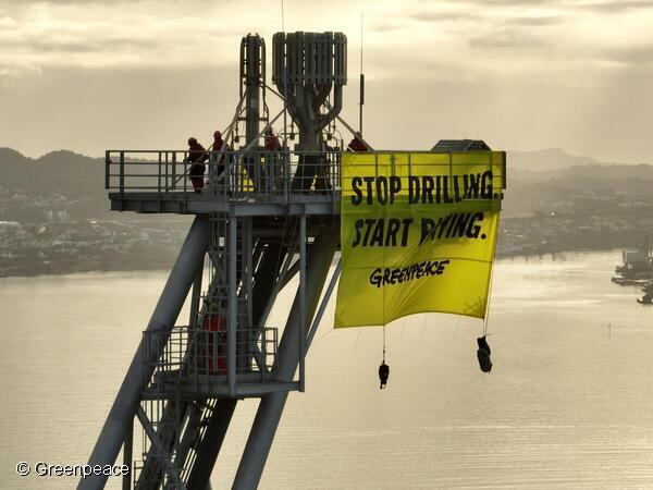Aktivister från Greenpeace ombord på Shells nya oljeplattform vecklar ut en banderoll i protest.