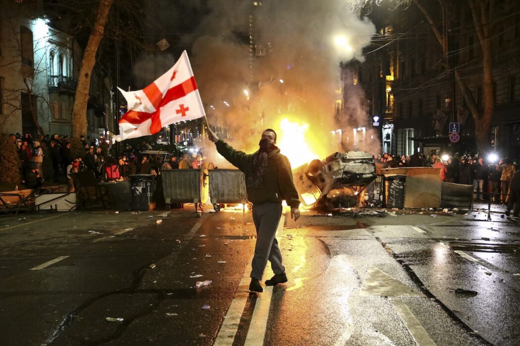 En demonstrant med en georgisk flagga i Tbilisi natten till torsdagen, före de nya beskeden om lagen.