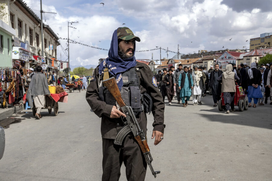 En talibansoldat står vakt vid en fredagsbön i Kabul i mars.