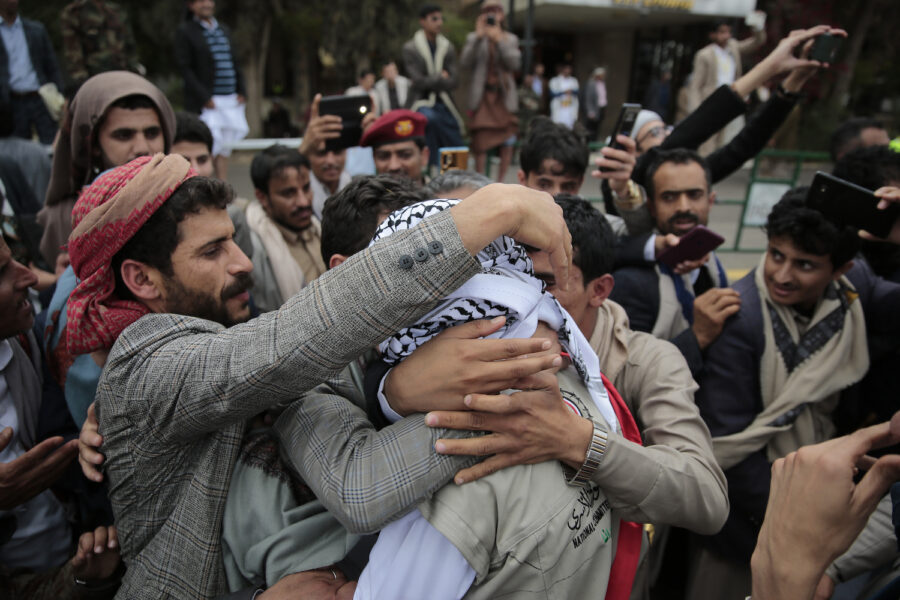 En fånge tas emot av nära och kära när han anlände till den rebellkontrollerade huvudstaden Sanaa på söndagen.
