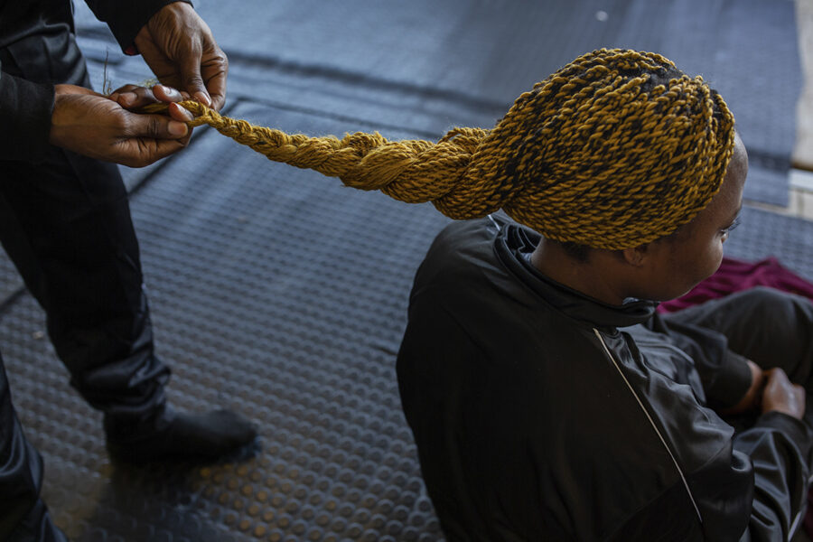 En kvinna flätar håret på Decrichelle.