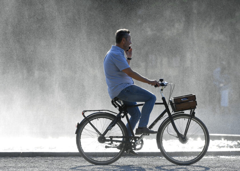 En man i Stockholm cyklar under den extremvarma sommaren 2018.