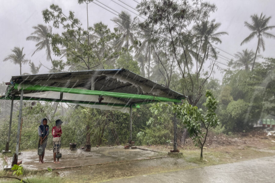 Två barn tar skydd från regnet i Sittwe i delstaten Rakhine.