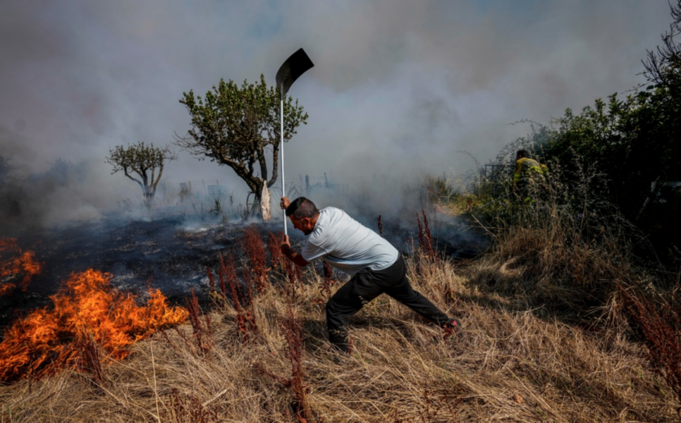 En privatperson försöker stoppa en brand från att sprida sig i Tabara i nordvästra Spanien förra sommaren.