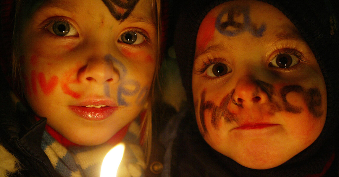 ”Give peace a chance” står det tvärs över ansiktena på Shiva och Luna Magnussen under en protest mot planerna på ett krig i Irak 2003.