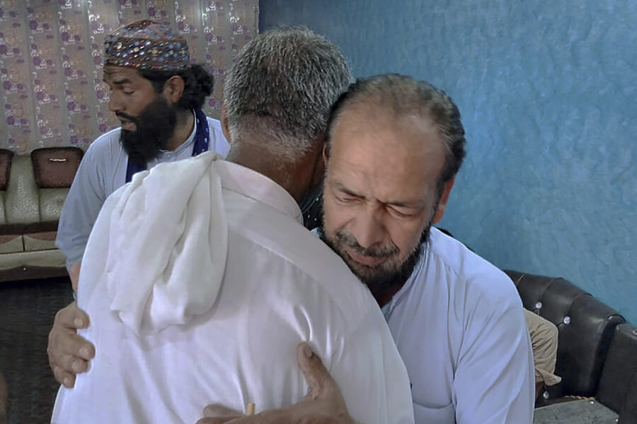 Raja Yousaf, till höger i bild, tröstas av vänner i byn Konti i den Pakistanstyrda delen av Kashmir.