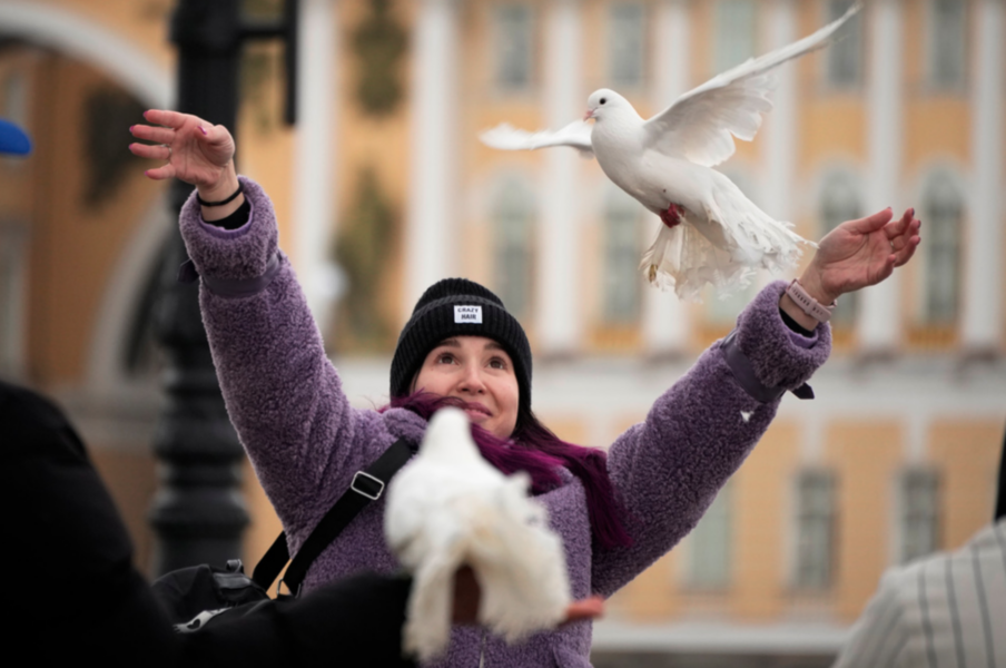 På bilden: En rysk kvinna som släpper vita duvor i Sankt Petersburg tidigare i år.