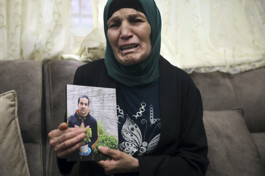 Rana Halak visar upp bilden av sin autistiske son som sköts ihjäl av polis i Jerusalem 2020.