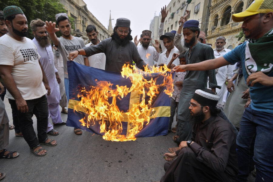 Anhängare till det radikala islamistpartiet Tehreek-e-Labiak bränner en svensk flalgga i Karachi.
