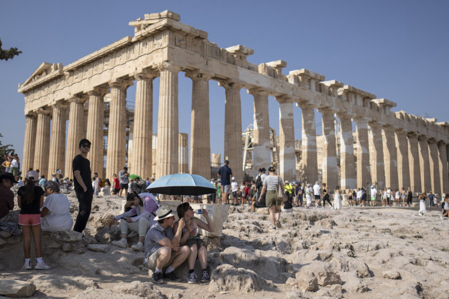 Utanför Parthenontemplet på Akropolis i Aten svettas turisterna.