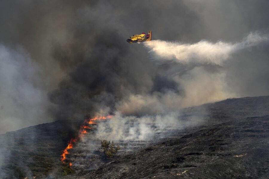 Ett Canadair brandflygplan släcker bränder över byn Vati på Rhodos.