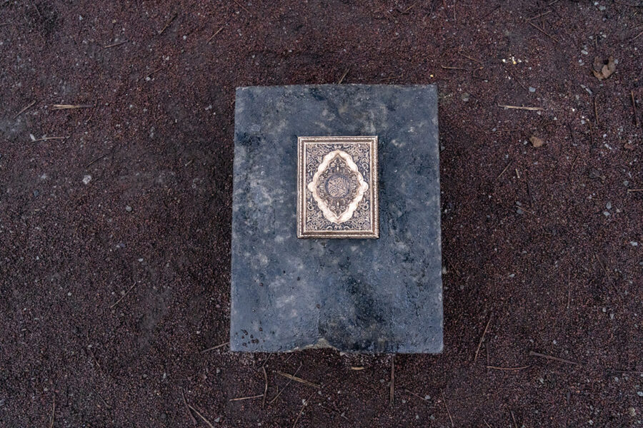 Ett konstverk i form av an koran i metall på ett fundament av sten i Magistratsparken i Malmö.
