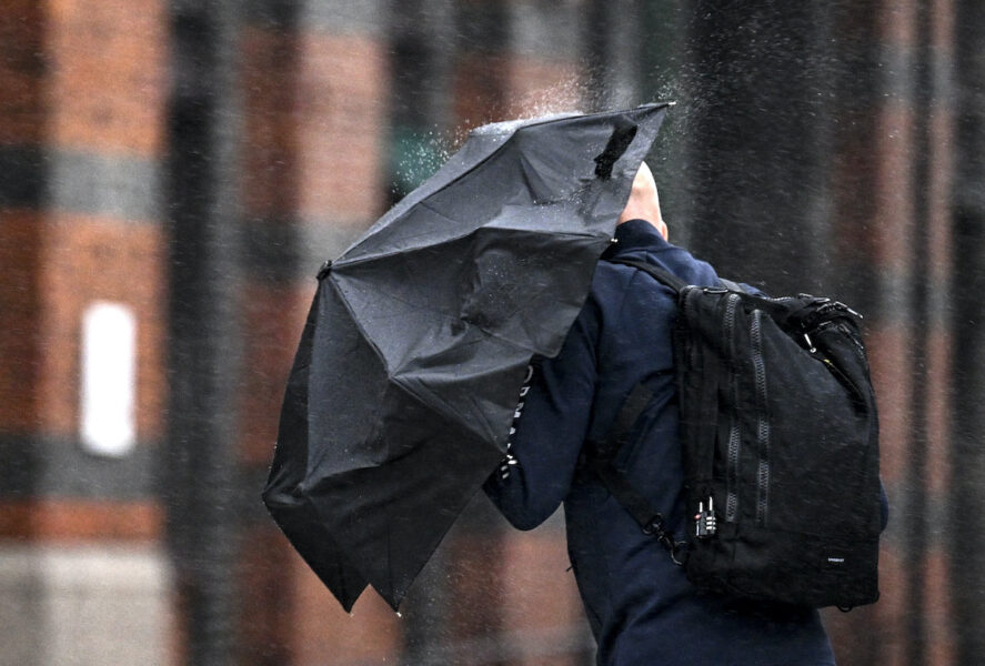 Med paraply som skydd mot regn på tvären vid Malmö C på måndagen.