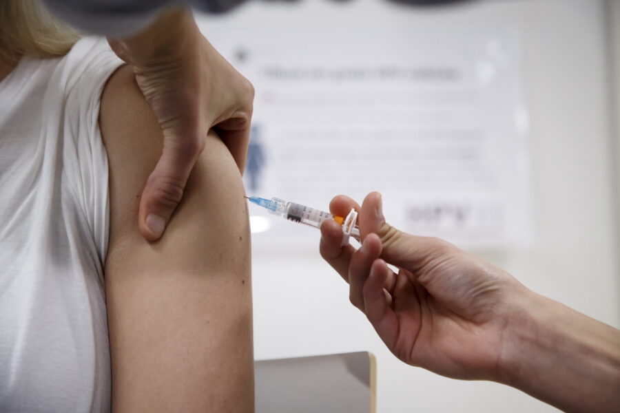 En kvinna får en spruta med hpv-vaccin.