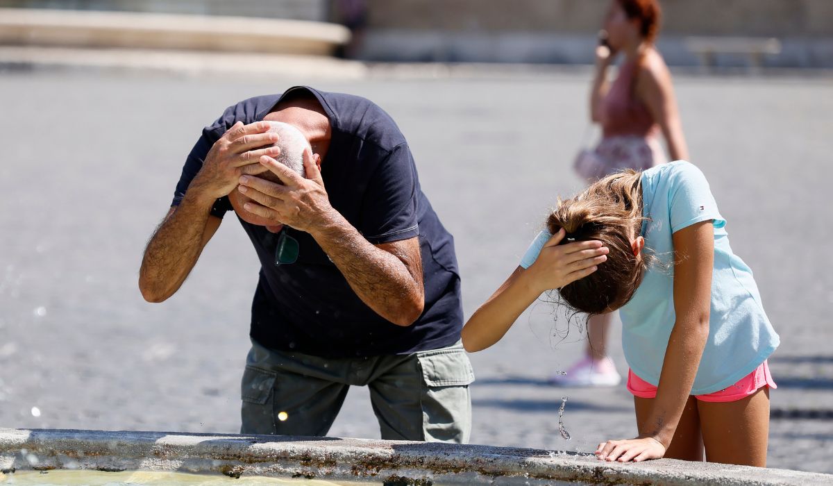 Turister svalkar sig vid en fontän i Piazza del Popolo i Rom.
