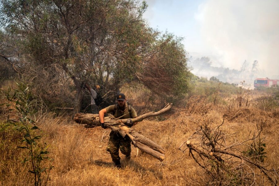 Frivilliga skär ner vegetationen för att förhindra att bränder på Rhodos, Grekland, sprider sig.