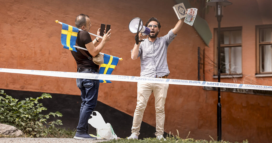 Salwan Momika filmas av en medhjälpare som bär på svenska flaggor.