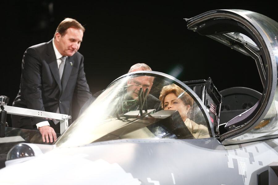 Saabs testpilot Jonas Jakobson visar Brasiliens president Dilma Rousseff det nya Gripen planet medan statsminister Stefan Löfven tittar på under besöket på Saab i Linköping.