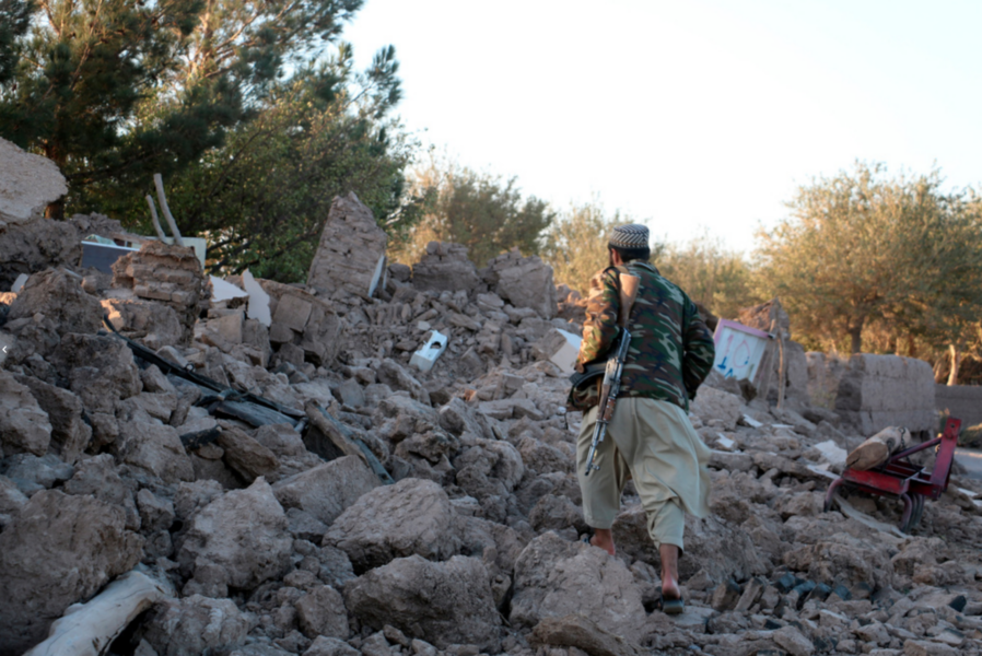 En afghansk man går förbi ett hus som förstörts helt av jordskalvet.