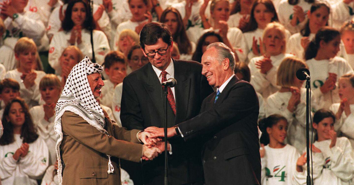 PLO-ledaren Yassir Arafat, Israels dåvarande utrikesminister Shimon Peres och Norges dåvarande utrikesminister skakar hand under en fredskonsert i Oslo.