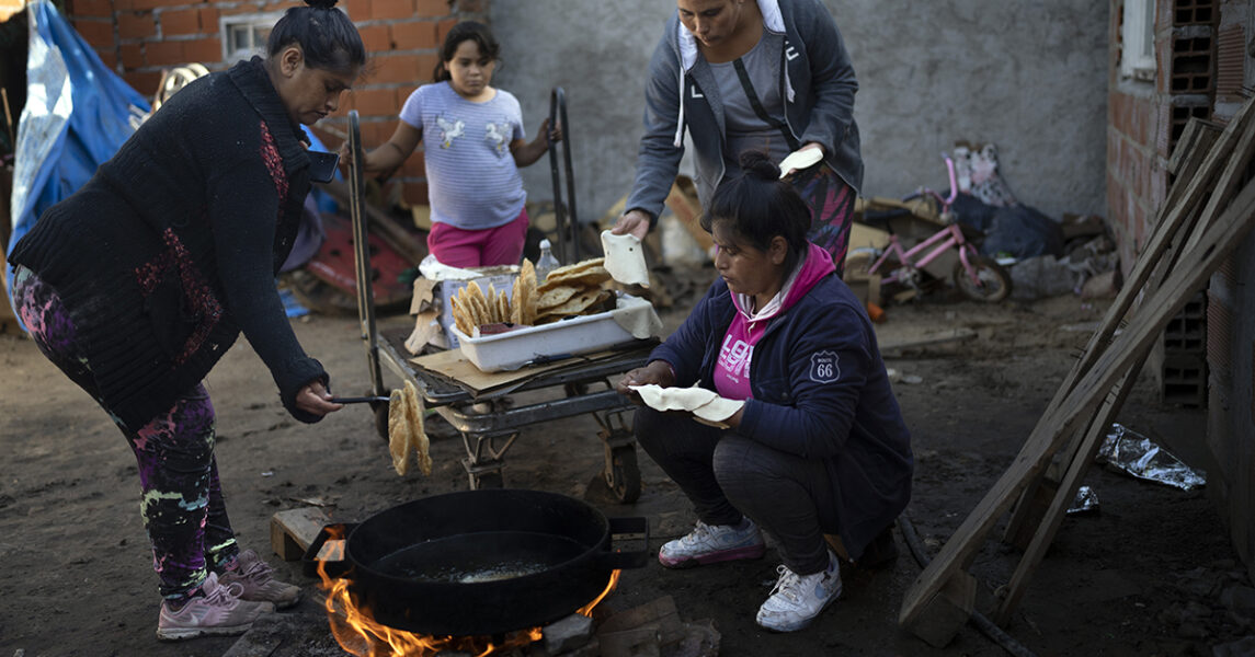 Fattiga argentinier friterarbröd till frukost i ett soppkök i Rosario i Argentina, där den som behöver kan äta gratis.