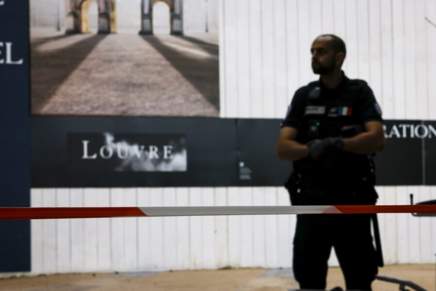 En polis vaktar Louvren i centrala Paris på lördagseftermiddagen.