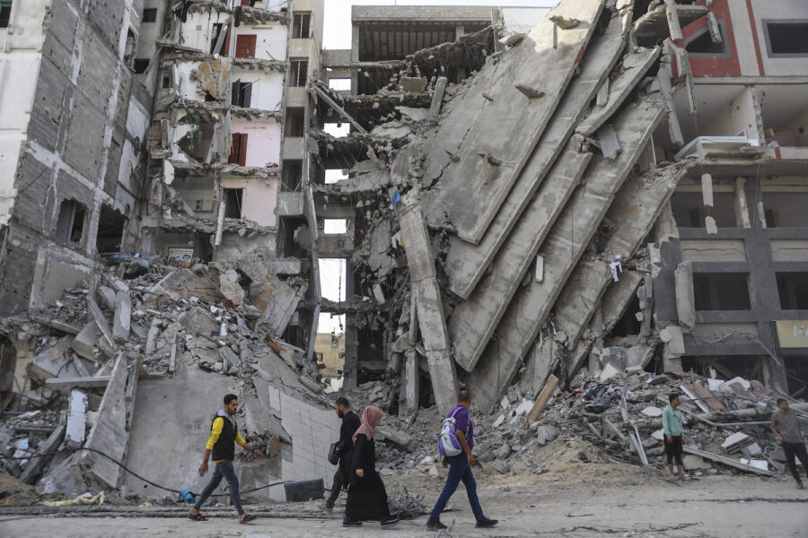 Palestinier går förbi sönderbombade byggnader i Gaza stad.