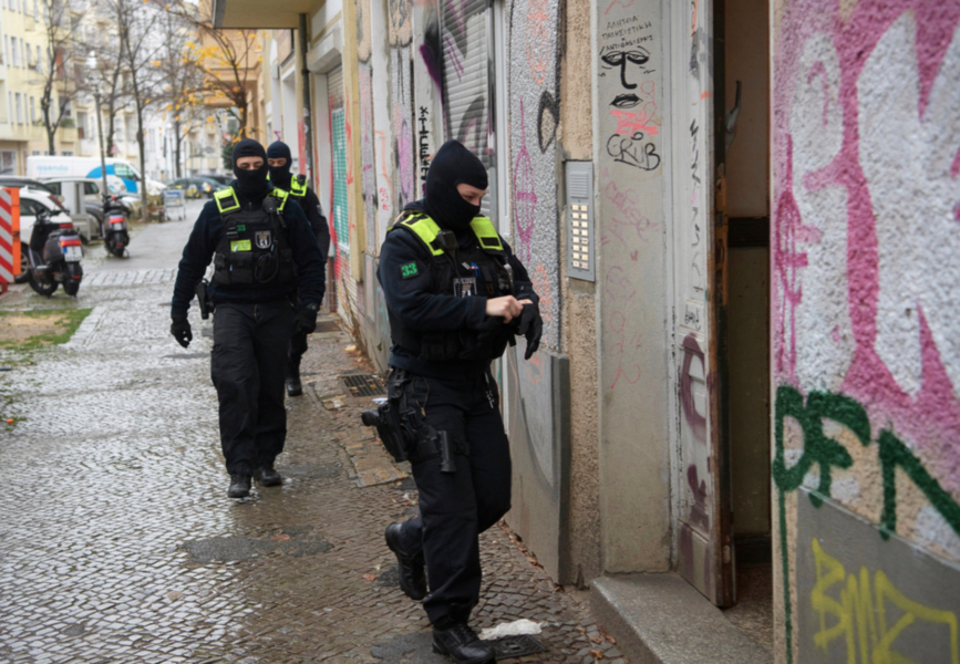 Poliser vid en av torsdagsmorgonens räder, här i Berlin.