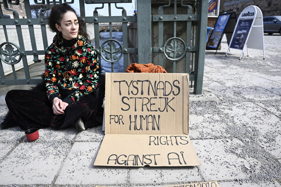 En ung kvinna demonstrerar i Stockholm för mänskliga rättigheter och mot riskerna som den nya AI-tekniken för med sig.
