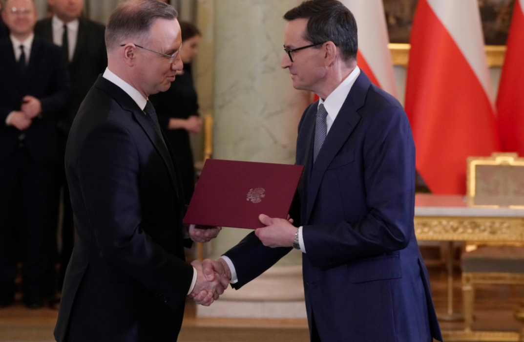 Polens president Andrzej Duda, till vänster, skakar hand med premiärminister Mateusz Morawiecki efter det att den sistnämnde svurits in på sin post på måndagen.