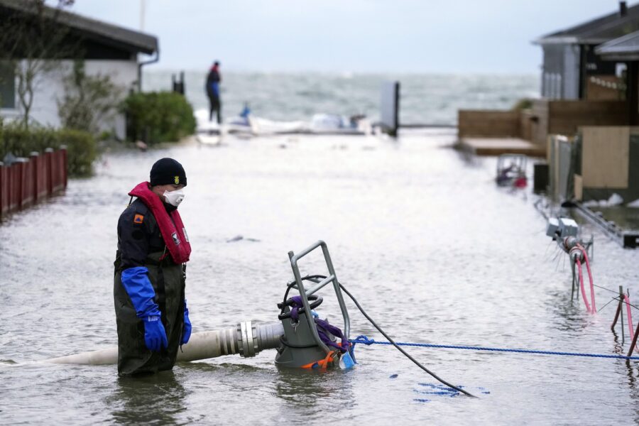 En invånare i danska Haderslev på Jylland försöker pumpa bort vatten som har översvämmat hans kvarter, den 20 oktober i år.